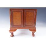 A small mahogany cabinet with two doors, 32 x 26 x 33 cm