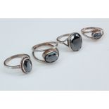 Four lady's hematite and white metal rings, all with bezel set oval faceted hematites in shanks