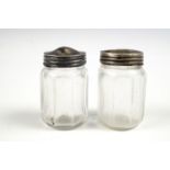 Two small white metal capped glass salt and pepper pots, the screw-on caps stamped "silver", circa