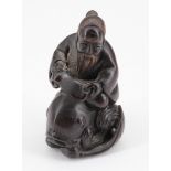 A Japanese carved wood netsuke of a man riding a fish, 5.5 cm