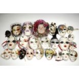 A large quantity of ceramic masks, largest 27 cm