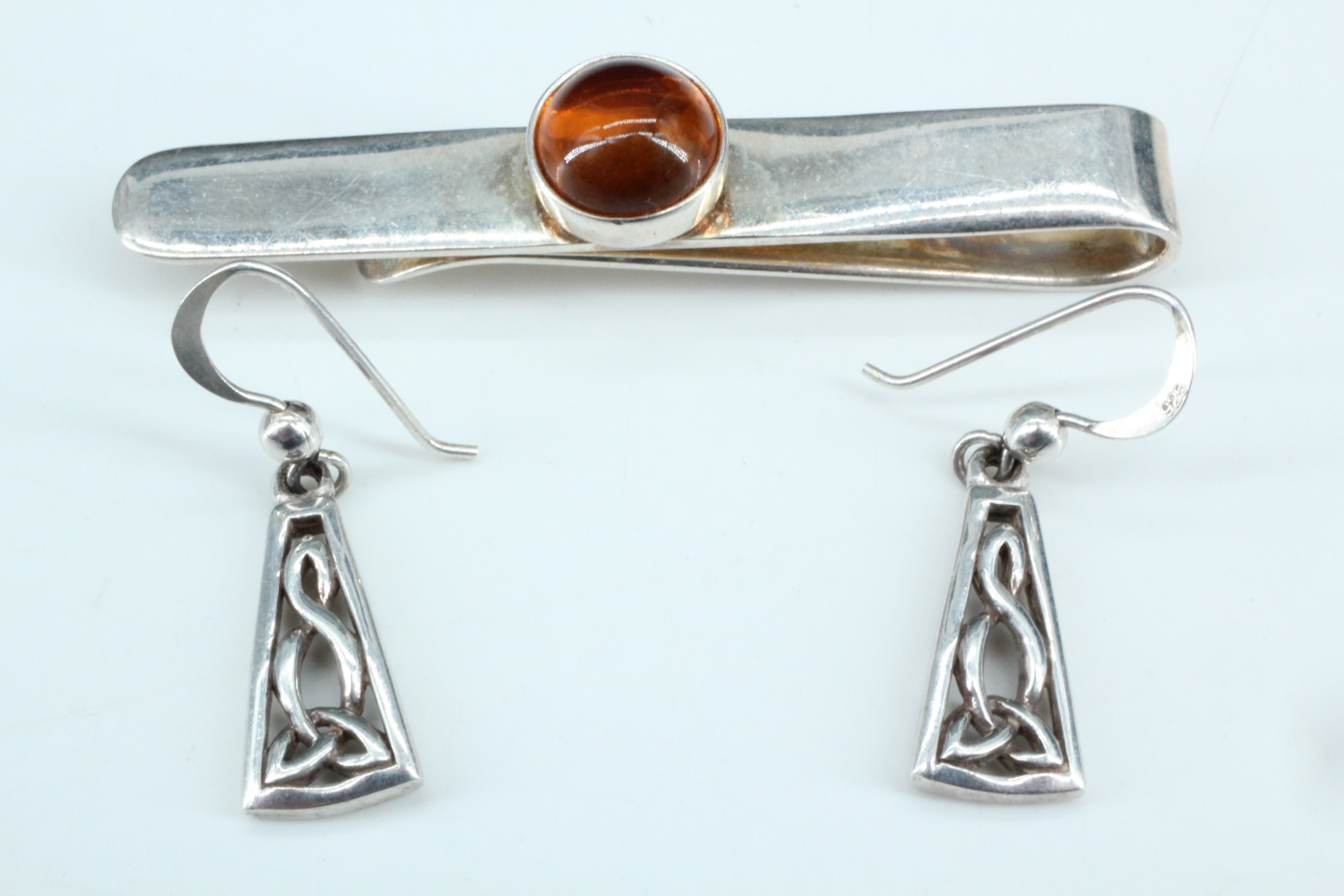 A pair of contemporary Celtic inspired white metal ear pendants, together with a silver money clip