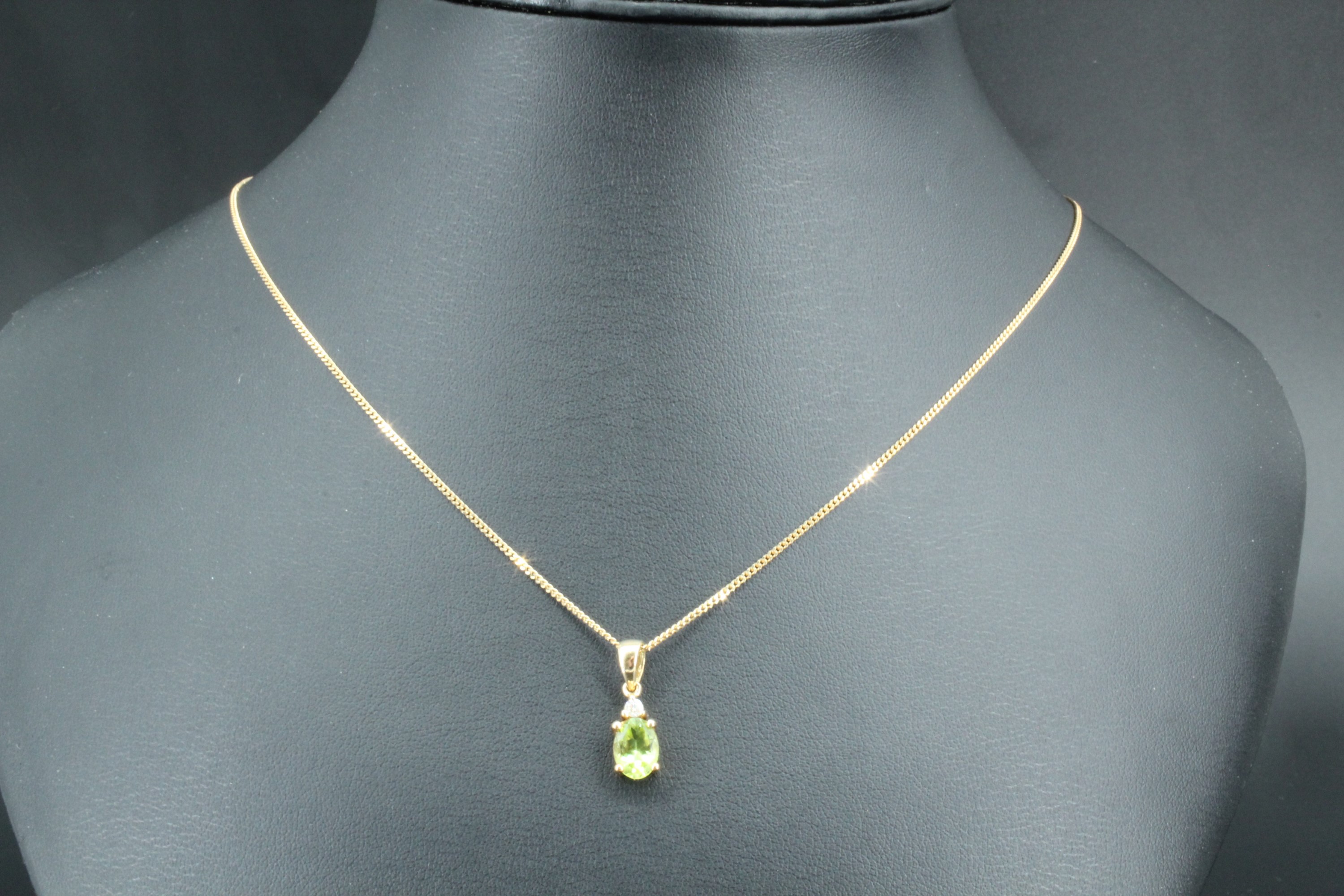 A peridot necklace, comprising an oval claw set peridot (8 x 6 mm) set below a small round - Image 2 of 2