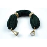 An early 19th Century miser's purse, in green mesh fabric with rolled gold collars and pendant fobs,