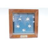 A framed display of five metallic Singapore flag stars bearing a plaque engraved "Visit of HRH The