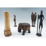 Five various African carved wooden ornaments including a stand in the form of an elephant, 20th