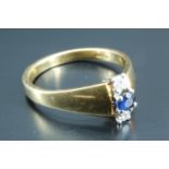 A contemporary diamond and sapphire ring, having a blue sapphire, approximately 0.1 carat, set