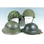 A quantity of largely British military helmets including a 1950s Royal Armoured Corps steel helmet