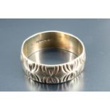 A 9 carat gold bright cut engraved wedding band, London, 1974, 3.73 g, 7 mm wide, size R/S