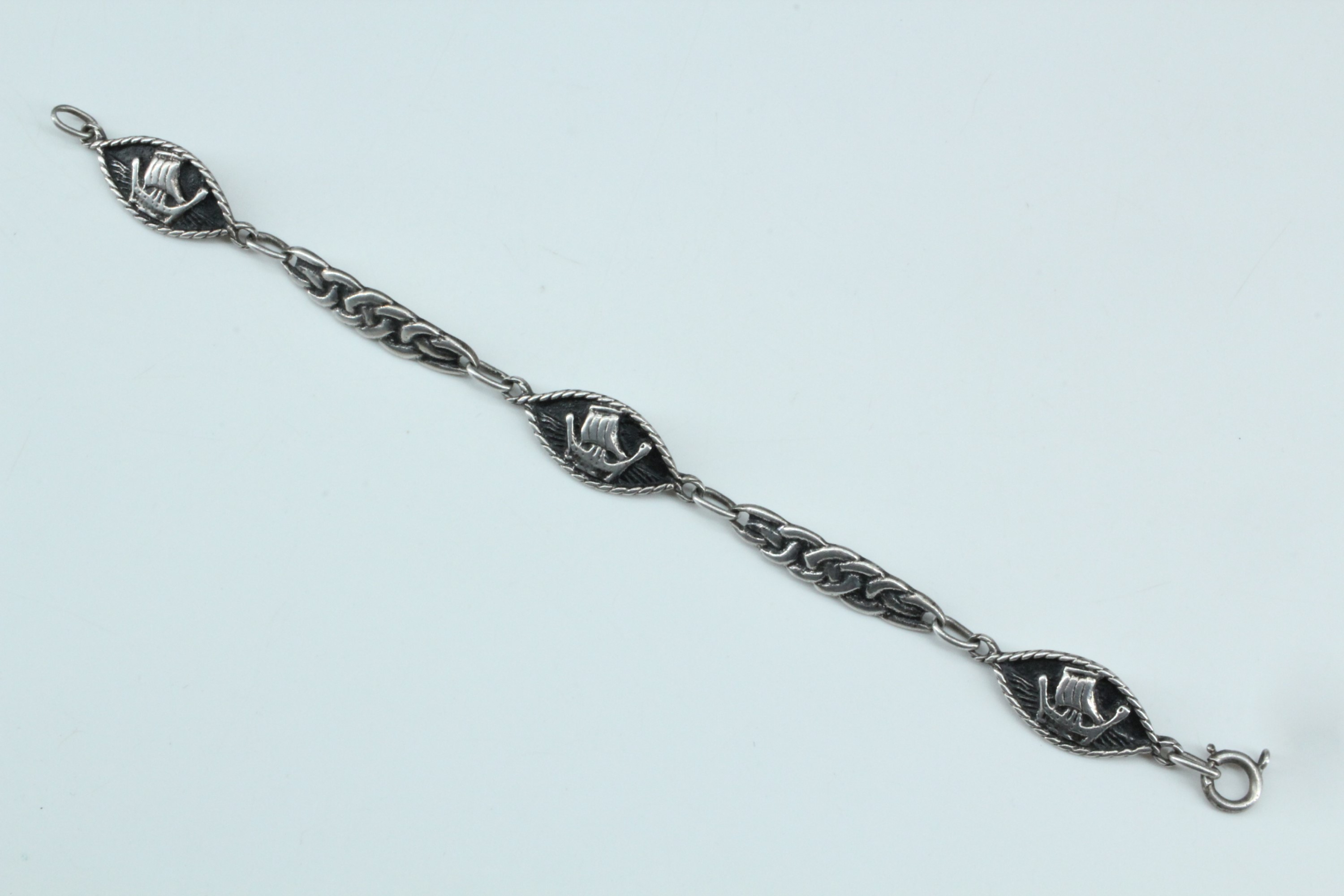 A Scottish Iona white metal bracelet, of Celtic interlace decorated links dividing lenticular