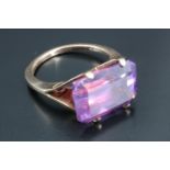 A large and striking amethyst dress ring, the shoulders parting into two panels, upswept to form the