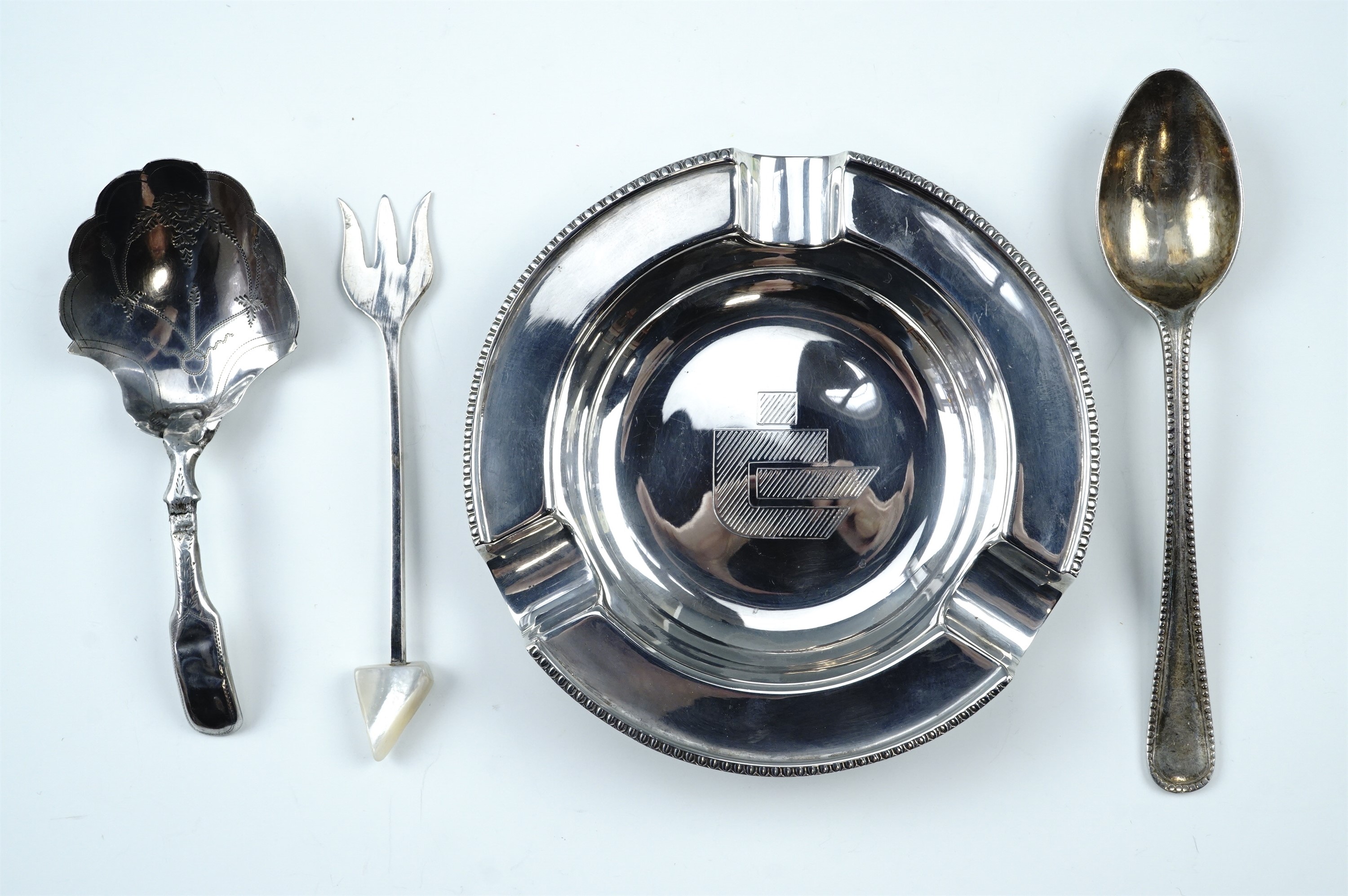 A Georgian silver caddy spoon together with a silver ashtray, a silver pickle fork and tea spoon