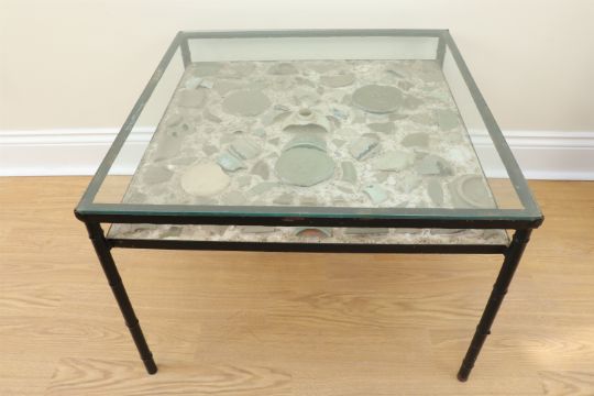 A late 20th Century glass topped coffee table incorporating a shelf set with shards of Chinese