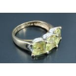 A contemporary three stone lady's dress ring, having a line of three yellow cushion cut square