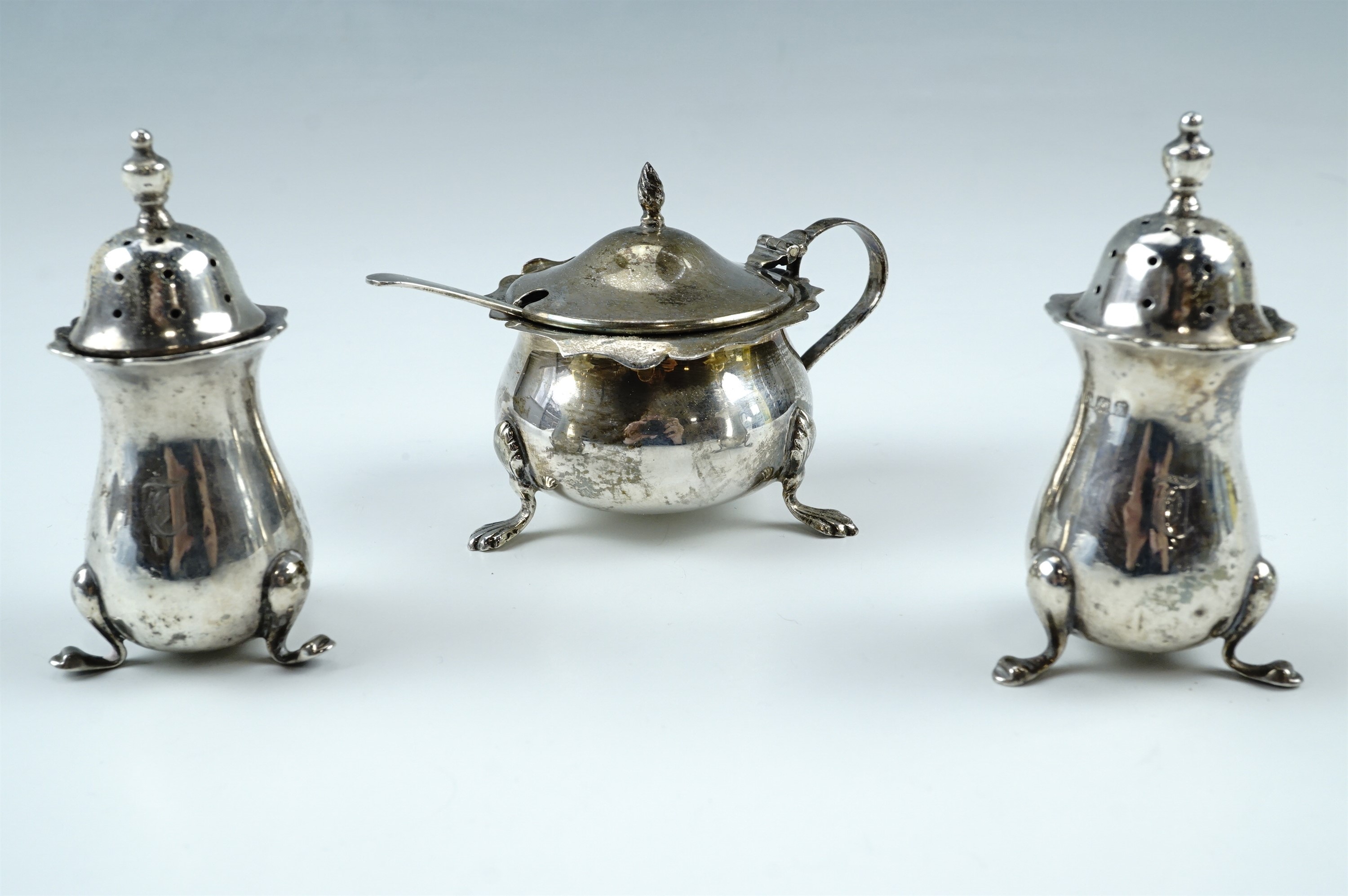 A pair of Mappin and Webb baluster shaped pepperettes, with pierced push fit lids and raised on