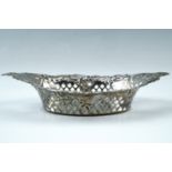 A late Victorian pierced silver bon-bon dish, being navette shaped and having repousse scrolls and