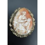 A Victorian shell cameo brooch depicting a kneeling female classical scholar, in a gilt metal