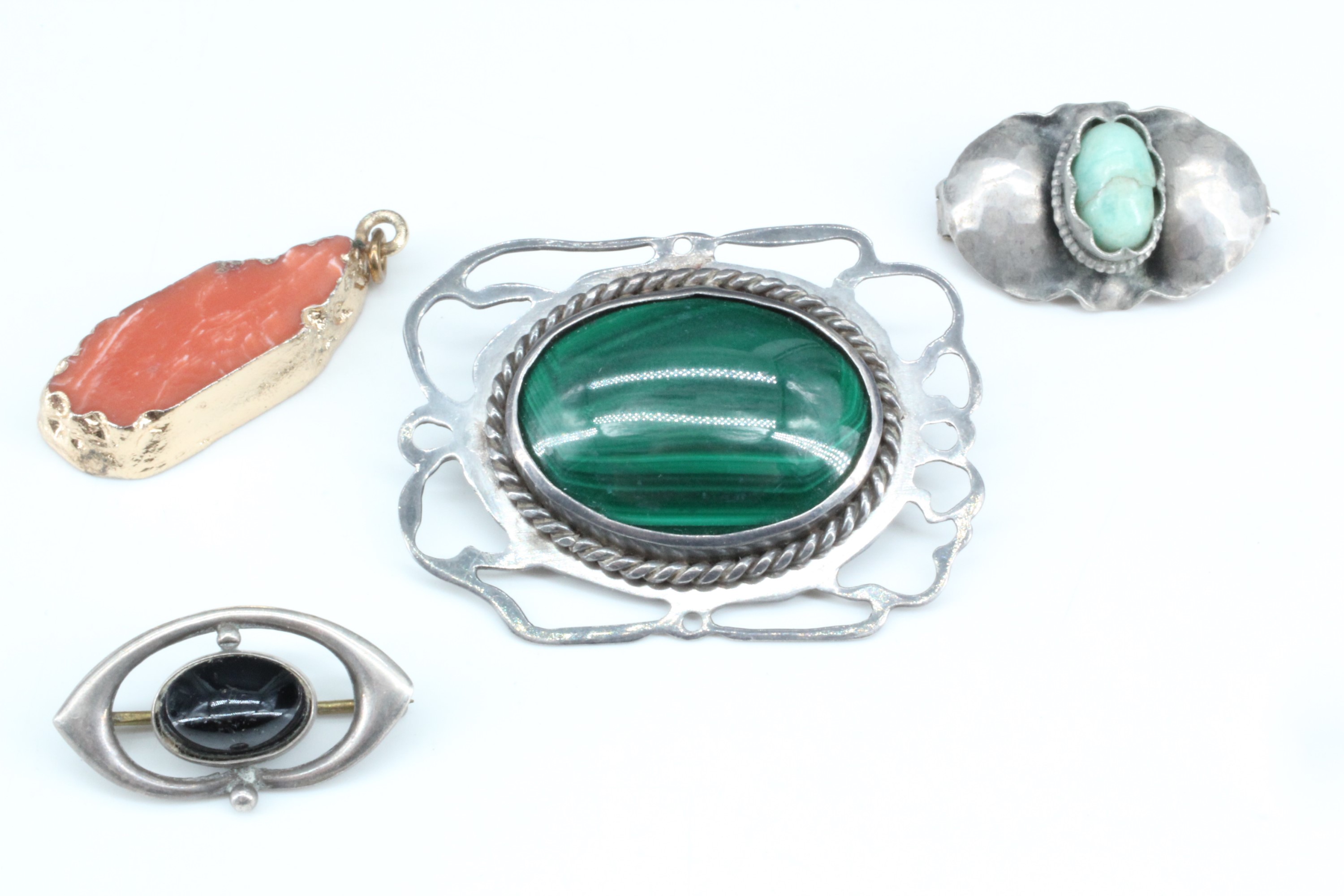 Three vintage brooches and a pendant, variously comprising mounted malachite, jade and coral