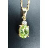 A peridot necklace, comprising an oval claw set peridot (8 x 6 mm) set below a small round