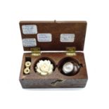 A mahogany box of curios including an early 19th Century fob magnetic compass enclosed in a yellow