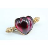 A late 19th / early 20th Century garnet brooch, being garnet carved into a heart, in a rubbed