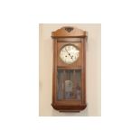A 1930s oak wall clock, spring driven and striking on a gong, 33 cm x 17 cm x 76 cm