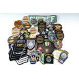A quantity of largely US police cloth badges, two police wall plaques etc