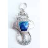 An Edwardian Arts and Crafts enamelled silver pendant, of geometric form, planished and centred by