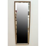 An antiqued-gilt framed dressing mirror, 126 cm x 43 cm