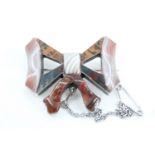 A Victorian Scottish polished hard stone and white metal ribbon-bow brooch, 3.5 cm x 3 cm
