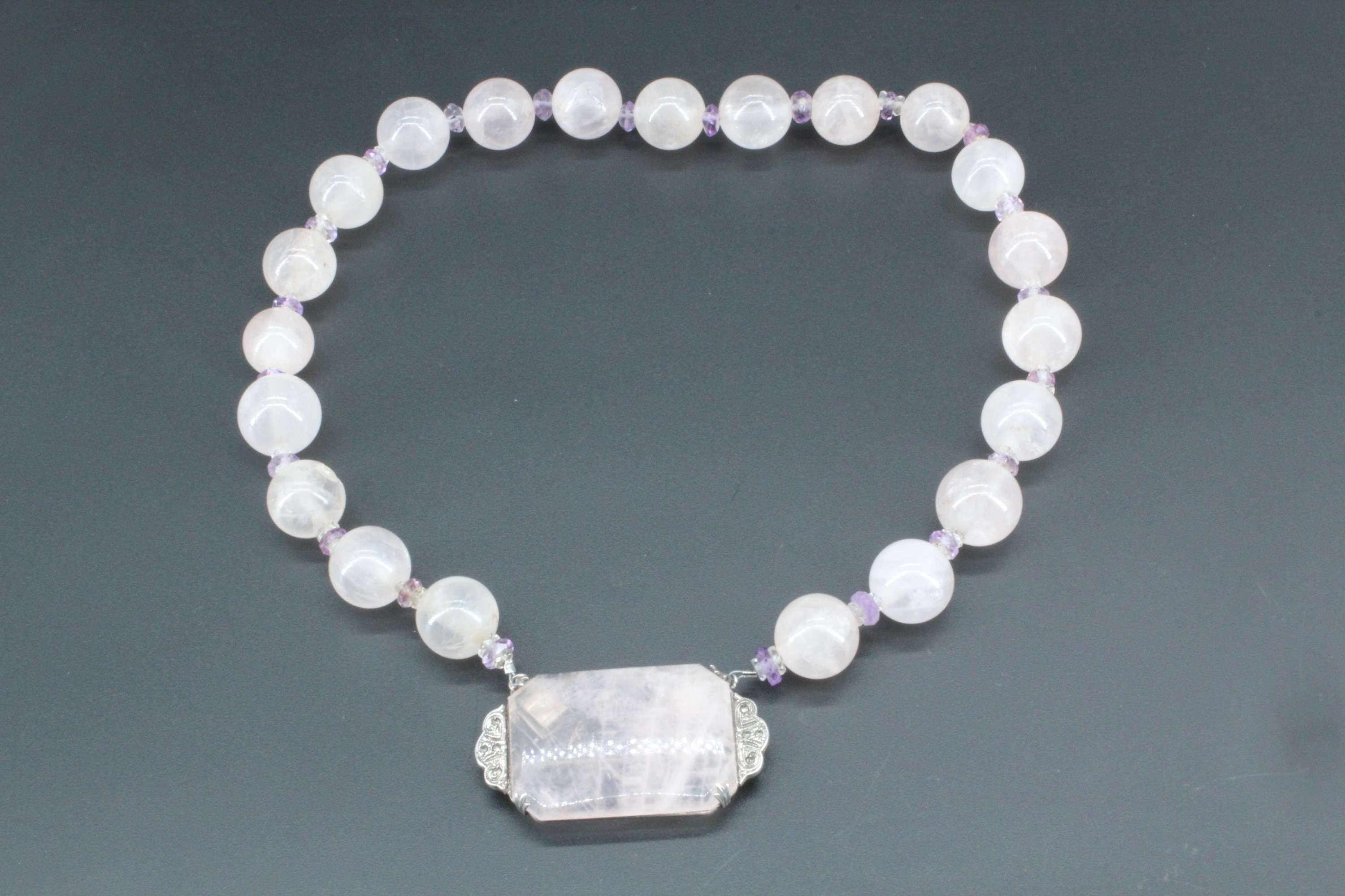 A vintage Art Deco rose quartz and amethyst necklace, of rose quartz spherical beads divided by