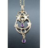 An amethyst set gold pendant, having floral scrolls suspending two pear shaped amethysts, 9 ct gold,