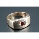 A 1970s garnet set gentleman's ring, having a curved oblong table with bark textured sides and