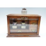 A late Victorian glazed oak desk-top writing and stationery cabinet, having lateral brass bale