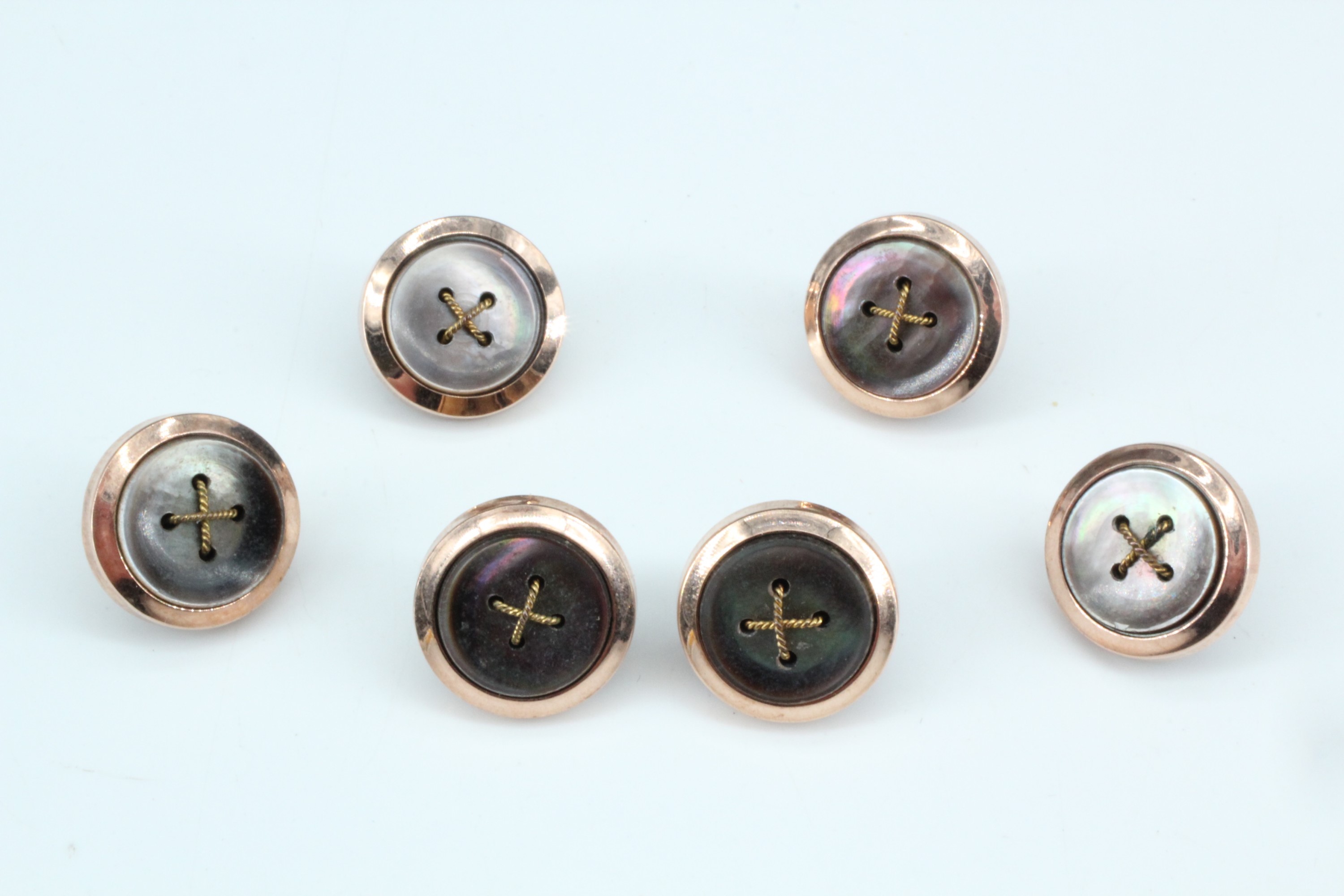 A set of six vintage rolled gold and faux tortoiseshell dress studs in the form of stitched buttons,