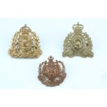 Three Canadian Mounted Police cap badges