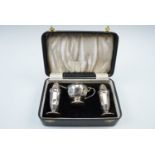 A 1930s cased silver, condiment set, comprising salt, pepper and mustard pots, the latter having a