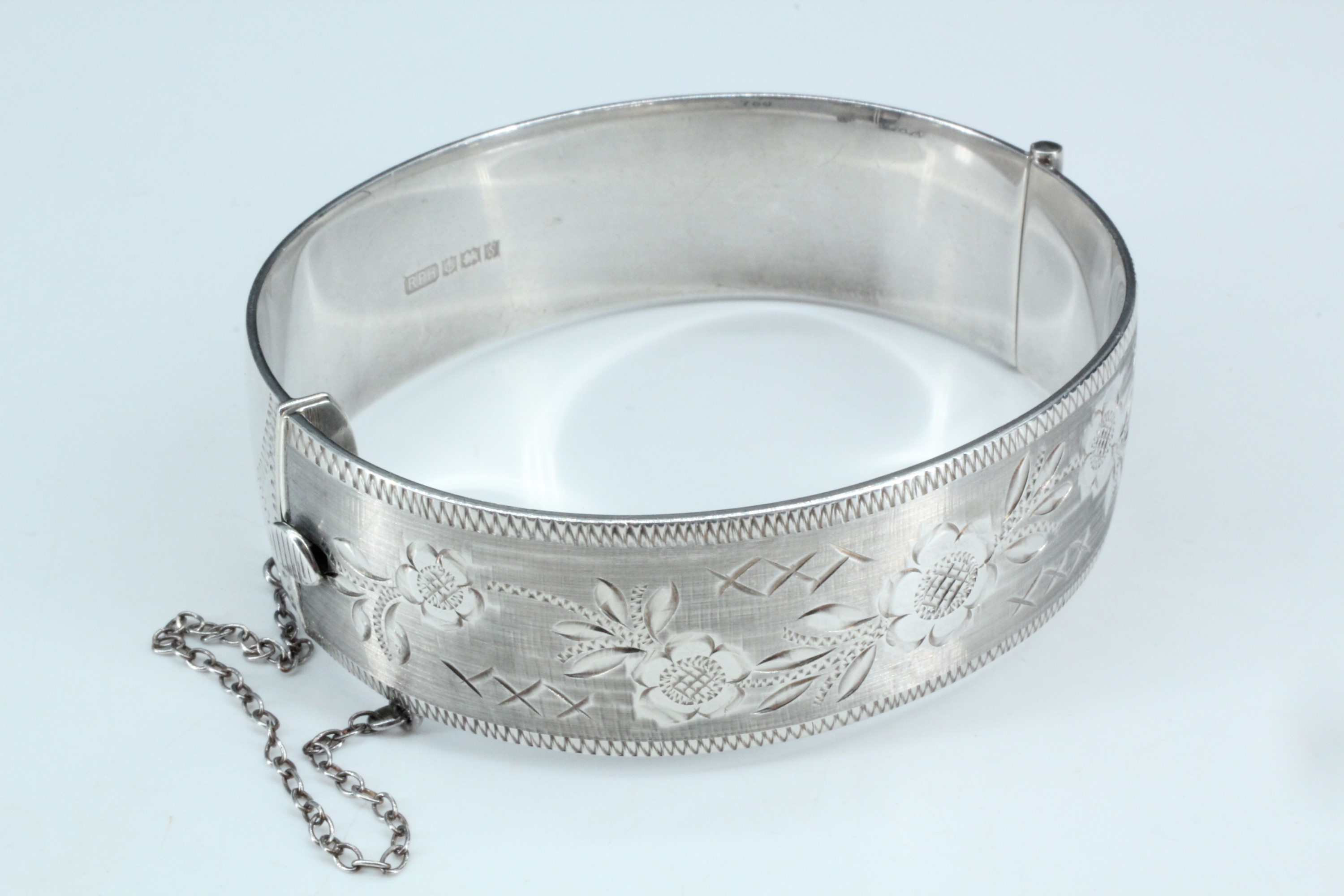 A floral-bright-cut silver bangle, hinged with a box clasp, Birmingham, 1967, 58 g, 5.5 cm