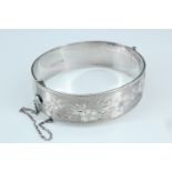 A floral-bright-cut silver bangle, hinged with a box clasp, Birmingham, 1967, 58 g, 5.5 cm