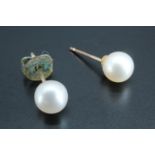 A pair of yellow metal mounted pearl stud earrings, pearls 5 mm, mounted testes as gold