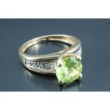A green semi-precious gemstone solitaire ring, the 8 mm round green brilliant cut stone set