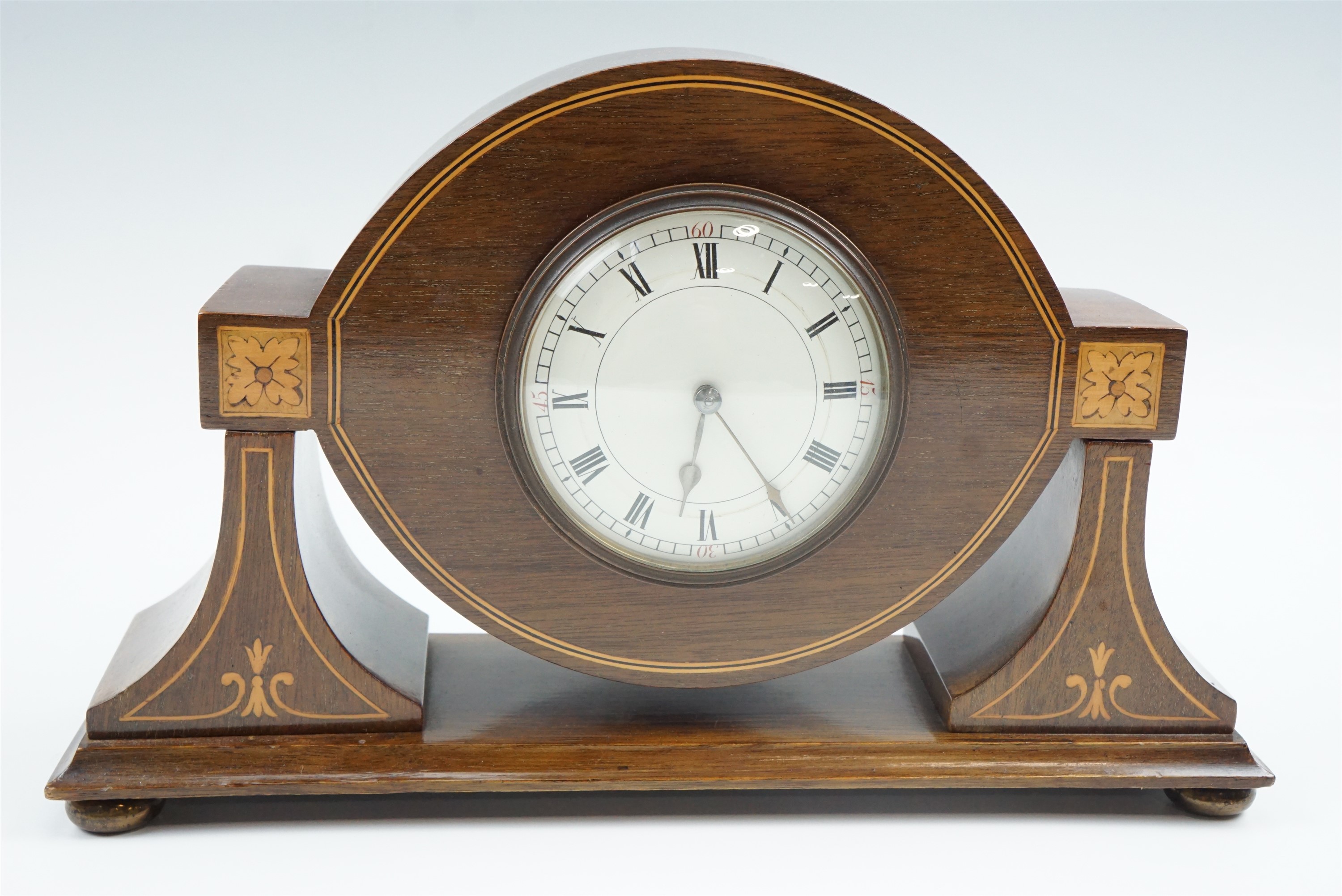 An Edwardian marquetry and string-inlaid mahogany mantle clock, having a French spring-driven