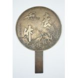 A Chinese polished bronze hand mirror, decorated with crane among bamboo and script, 20 x 29 cm