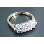 A lady's 14 carat gold cluster set dress ring, having a line of five 2 mm diameter cubic