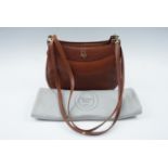 A Christian Dior brown leather handbag with original storage bag