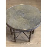 A Middle Eastern brass topped table with folding legs, 60 cm