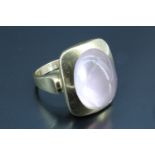 A 1970s rose quartz cabochon finger ring, having a 15 x 11 mm, oval cabochon, bezel set in an oblong