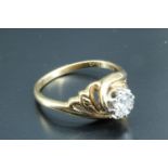 A diamond solitaire ring, having a 0.15 carat diamond, illusion set in a white metal crown, the