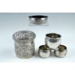 An Asian white metal ashtray together with three similar napkin rings, second quarter 20th