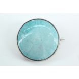 An Arts and Crafts Ruskin Pottery cabochon brooch, the mottled pale blue glazed cabochon
